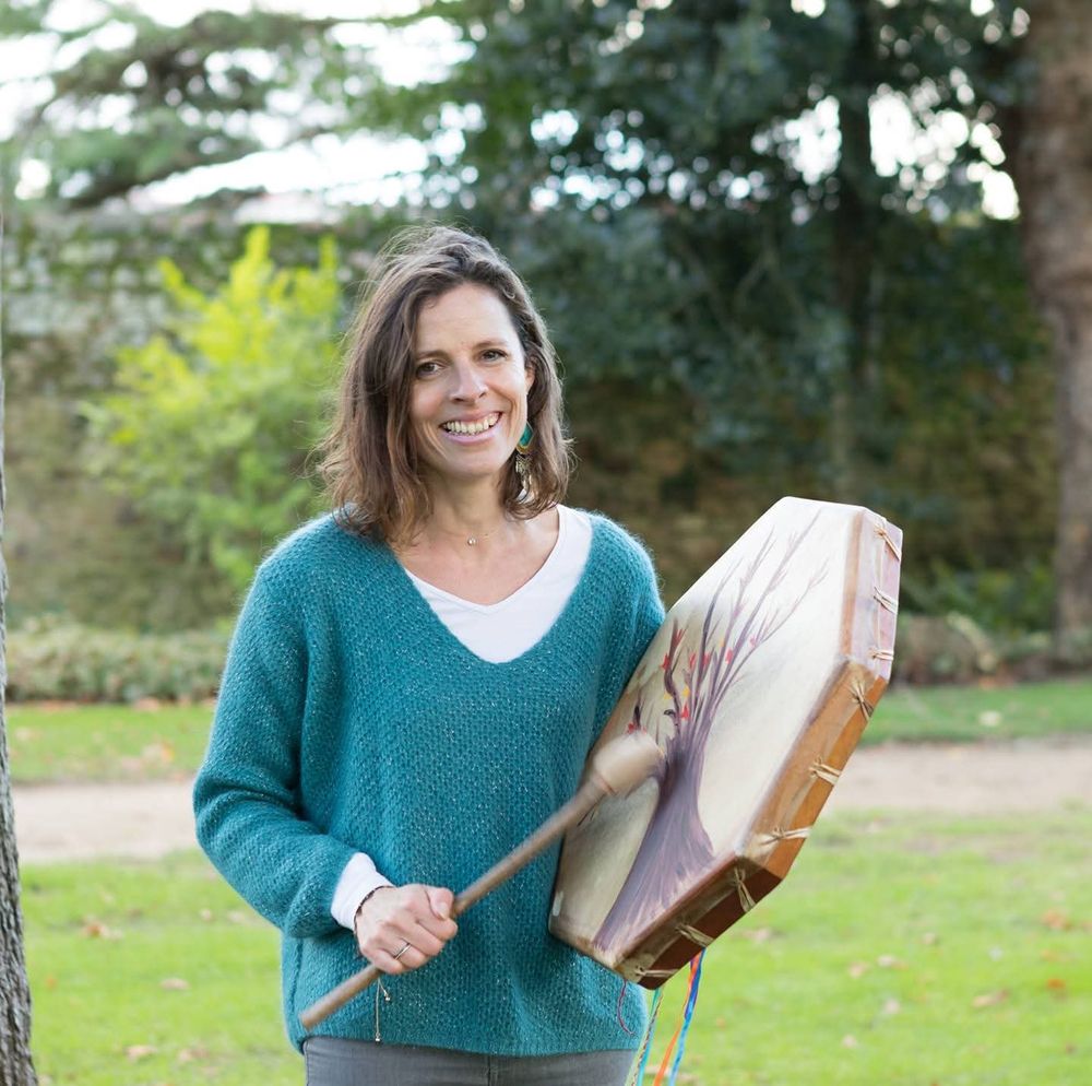 Séverine Alleno, magnétiseuse, dans un parc avec son tambour chamanique peint